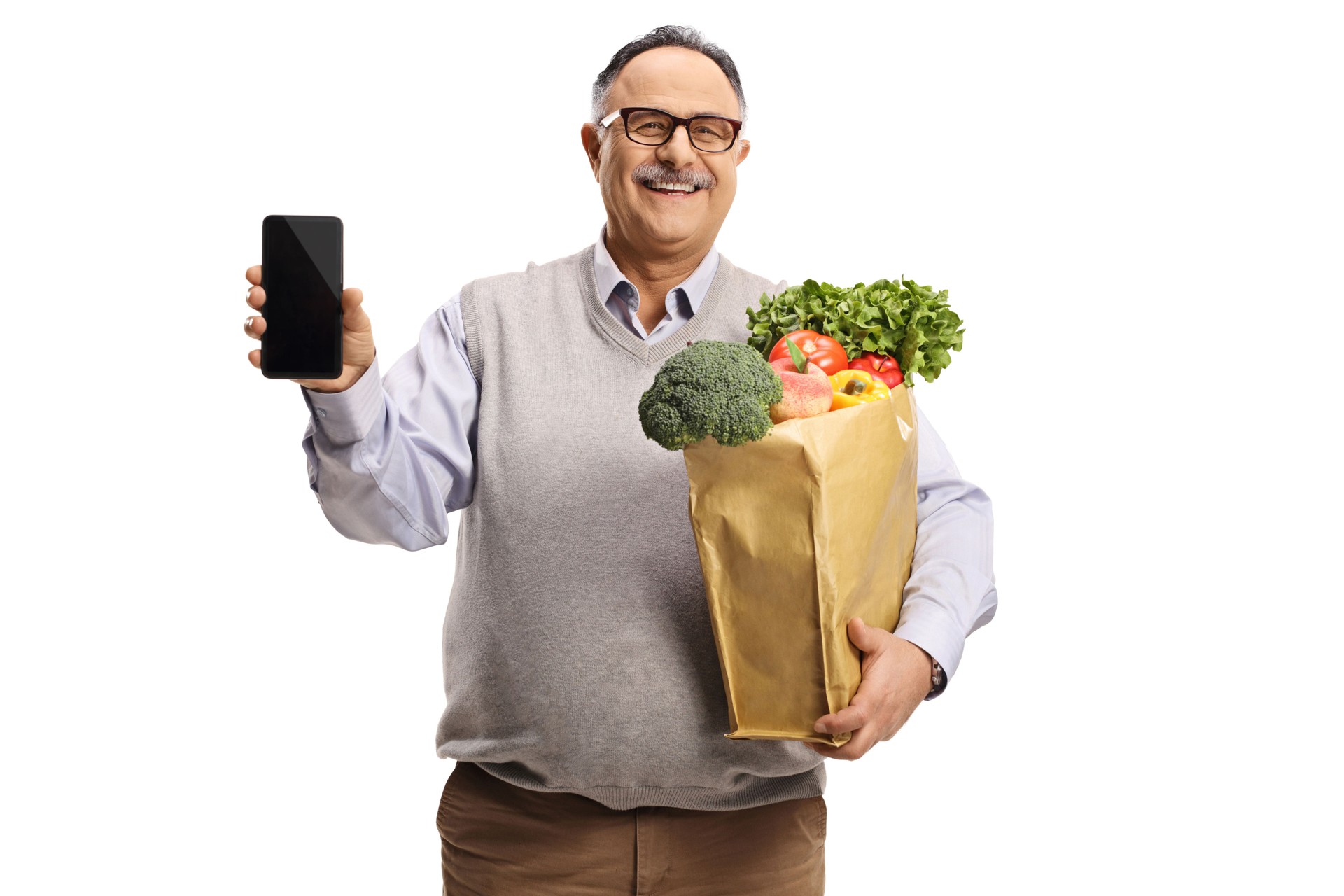 Mature man holding a grocery bag with healthy food and showing a smartphone